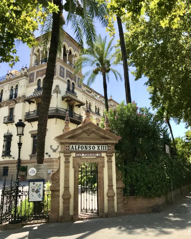 A brown building's entrance gate with Alfanso XIII written on it.