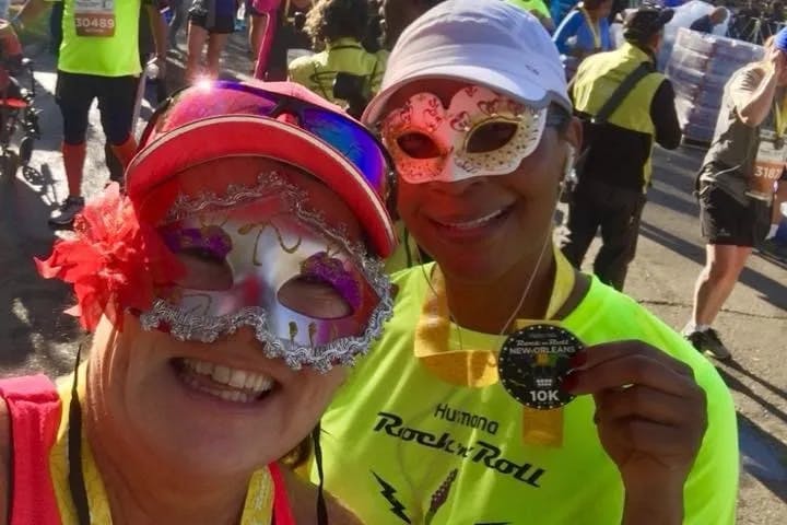 A selfie of two women wearing masquerade masks outside