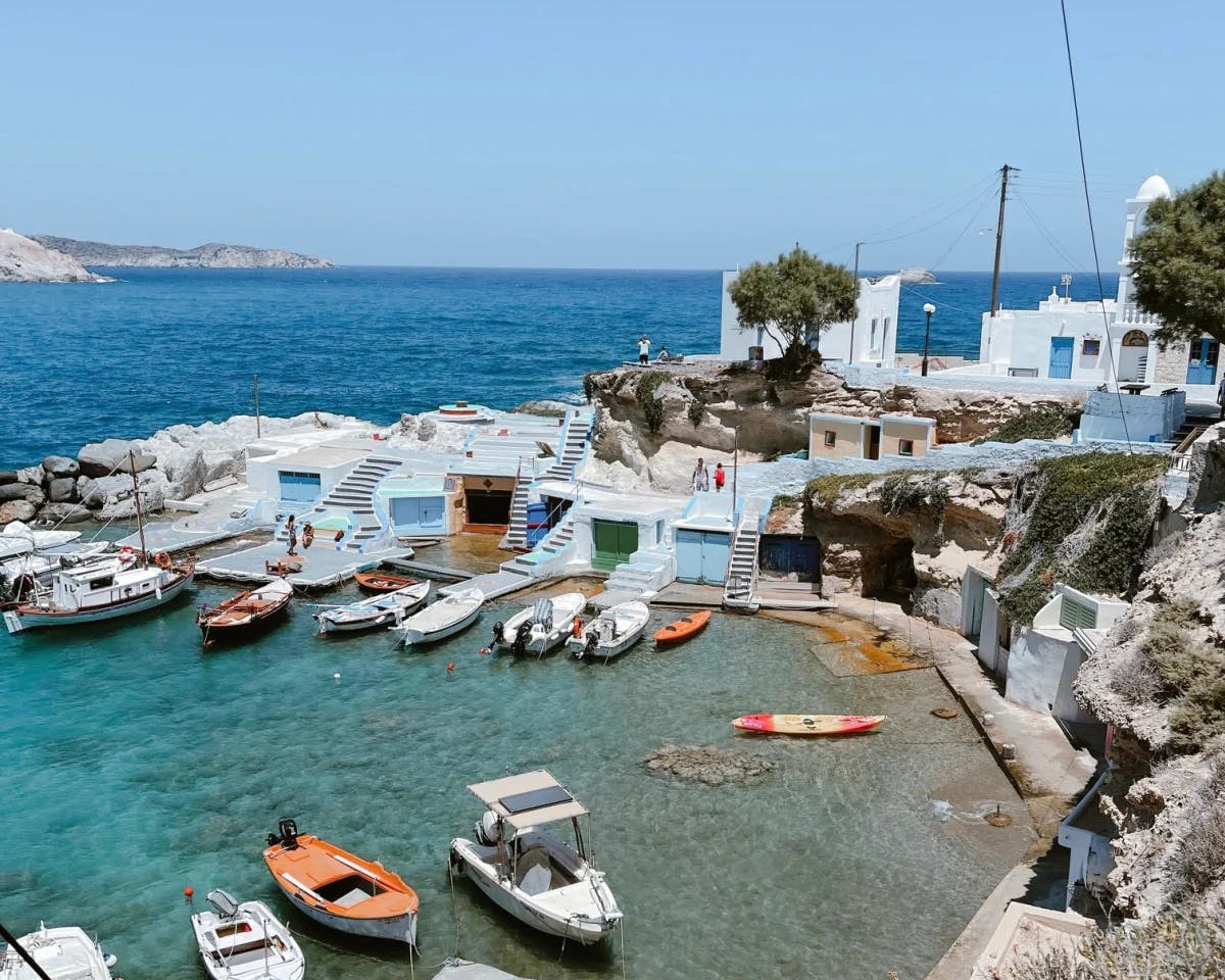 A dock with boats and blue sea in the background. 