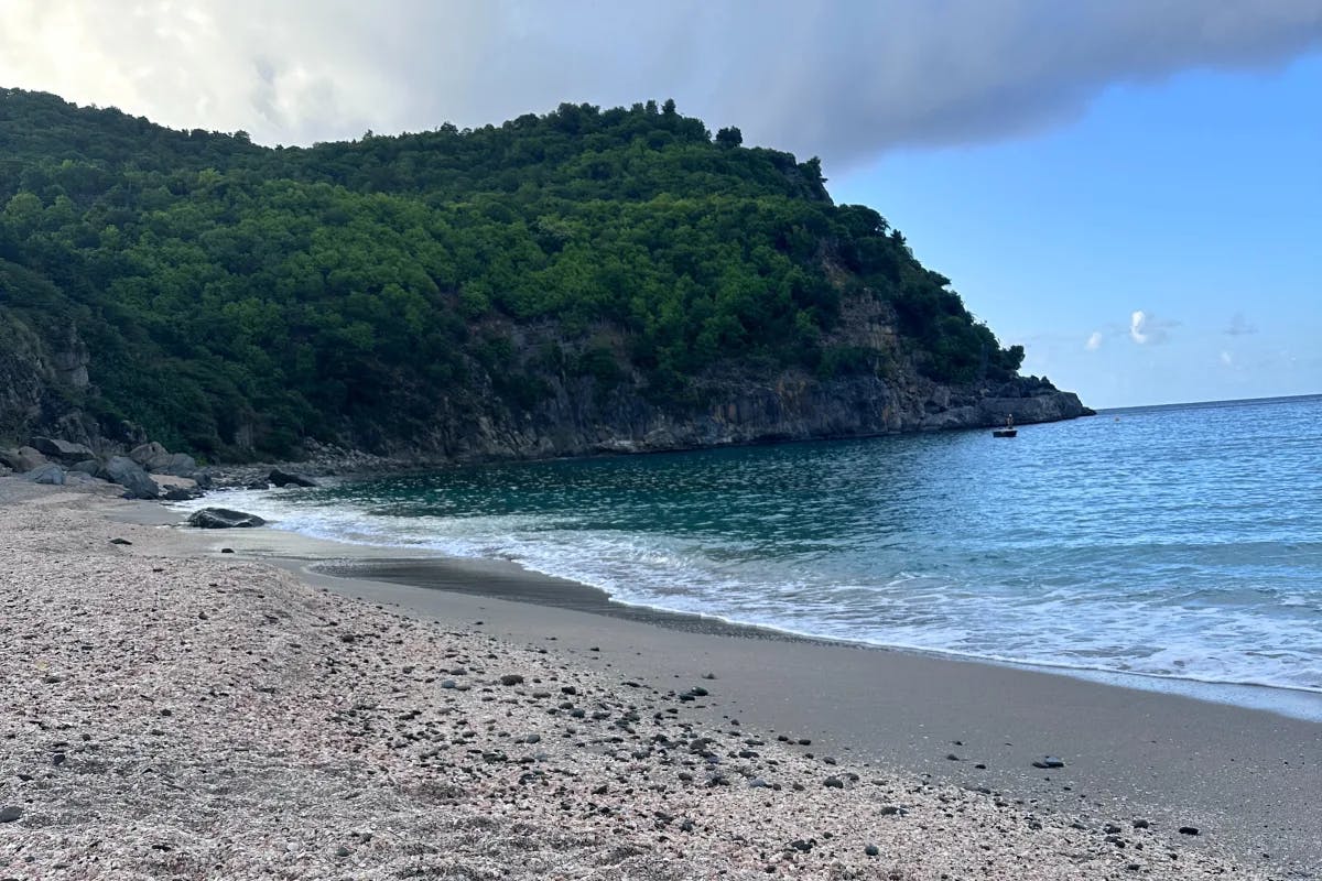 Waves gently lap the shore of Shell Beach on a cloudy morning at daybreak. 