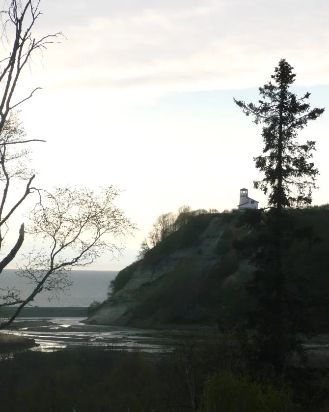 View of a light house on a cliff late in the day