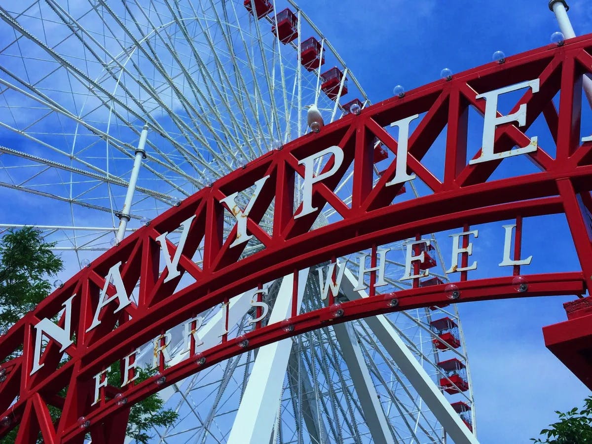 A red and white ferris wheel under blue sky during daytime.