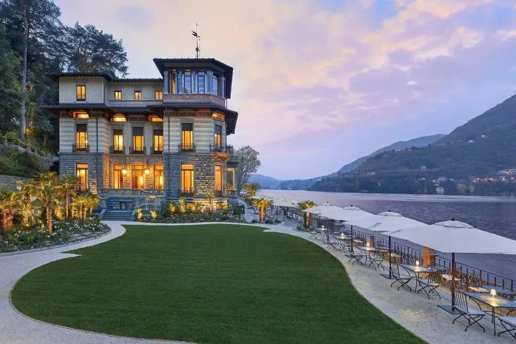 A well-manicured courtyard runs up to the shores of Lake Como and a classic villa-style hotel