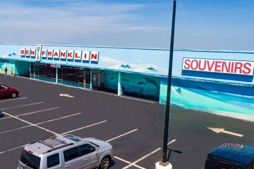 Large blue building housing the Ben Franklin souvenirs store and parking lot