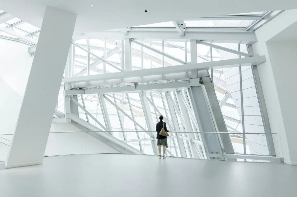 a woman stands in a white modern room