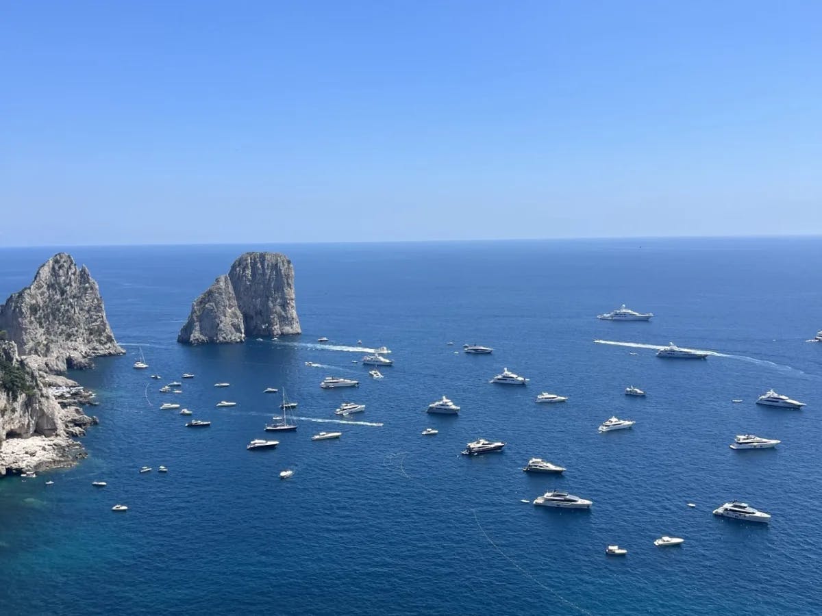 Aerial view of the ocean with lots of boats in the water