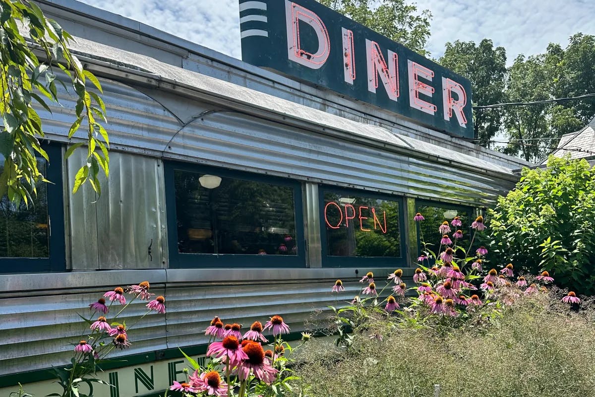 The exterior of a diner with flowers in front