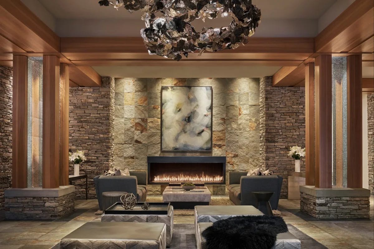 a cozy hotel lobby with a lit fire place and modern furniture