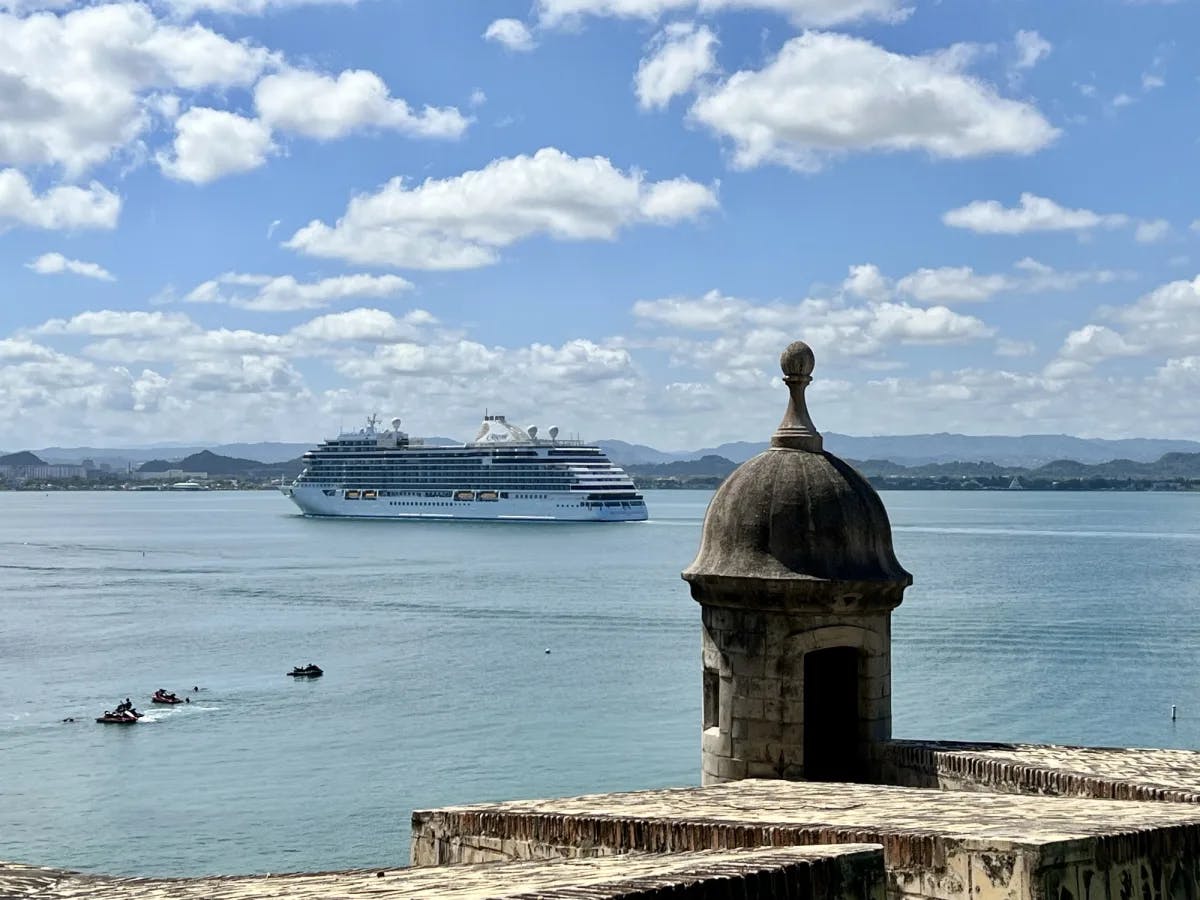 A view of a large cruise ship in the ocean on a sunny day. 