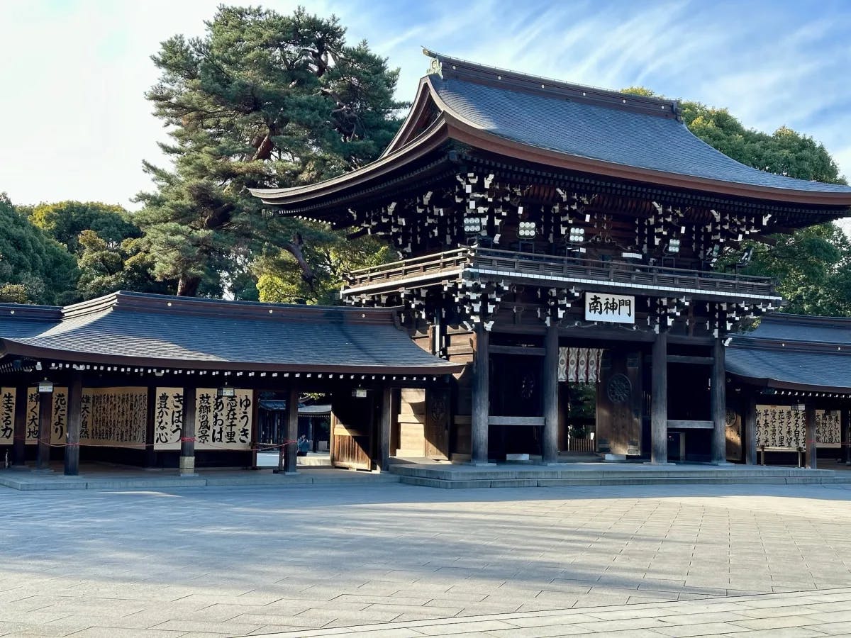 A temple in Tokyo made up of one large building and two smaller buildings with traditional structure and Japanese letters on the buildings