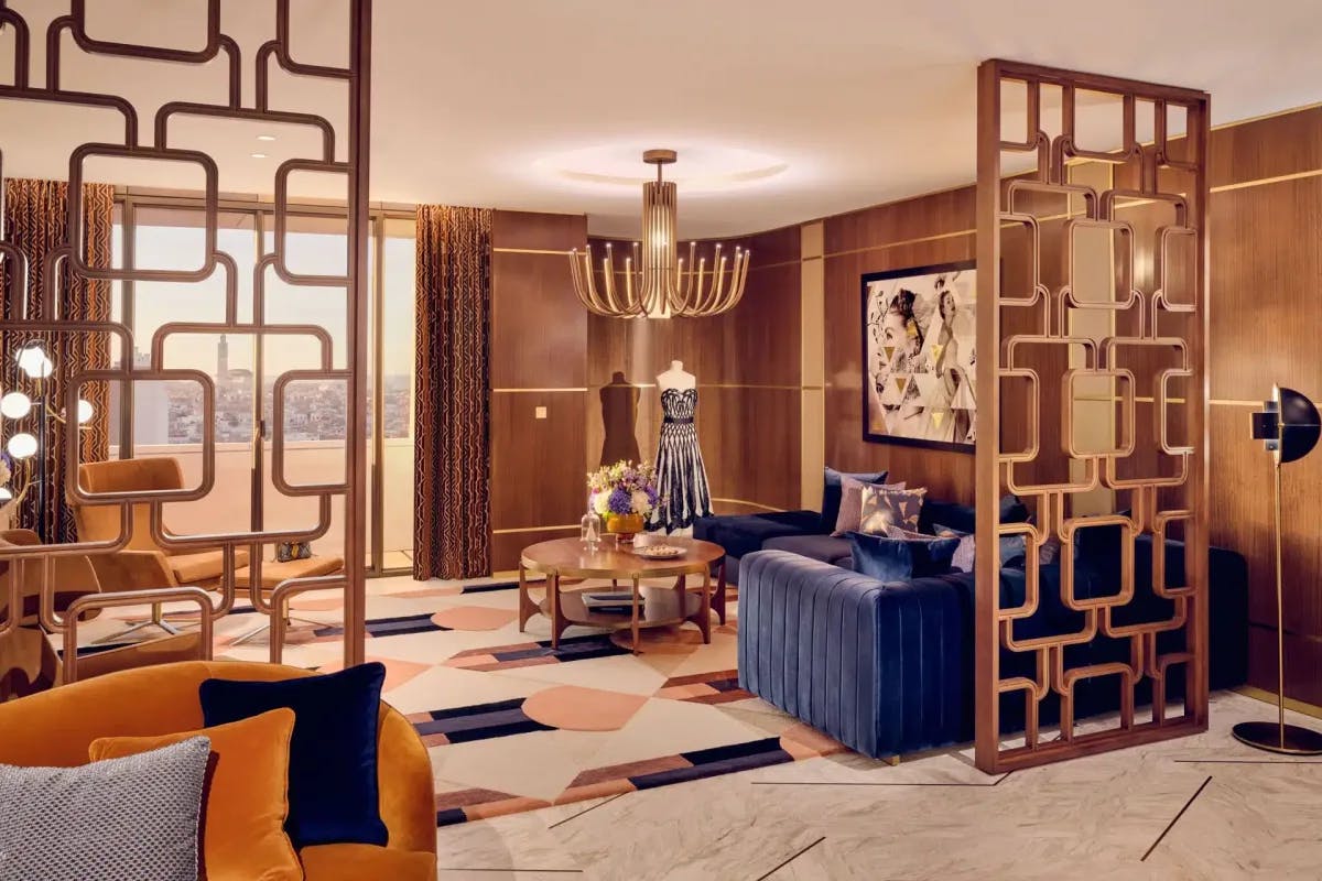 a fancy retro living room with orange and blue furniture and artistic floor-to-ceiling dividers