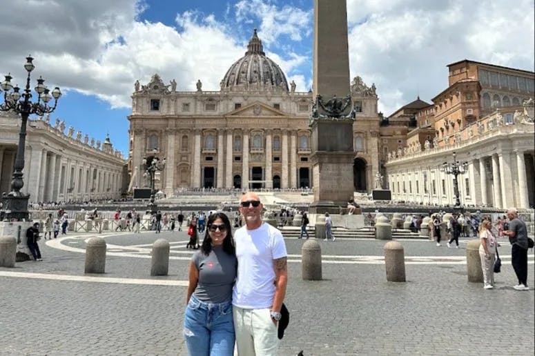 Mariela and a man at St. Peter's Square, a large plaza in front of St. Peter's Basilica in Vatican City.