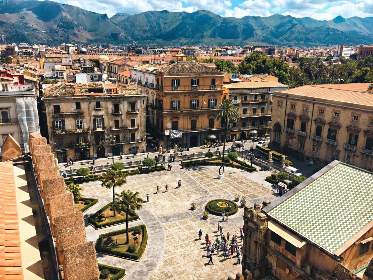 Aerial view of a village with old-looking buildings with mountains in the background.