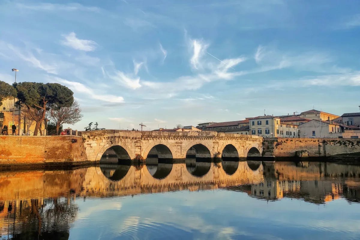 A picture taken from a far of an ancient bridge during daytime.