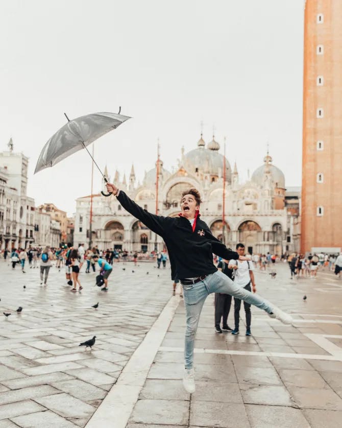 Travel advisor posing on the outside holding an umbrella