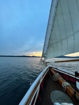 A sailboat in the water during a sunset