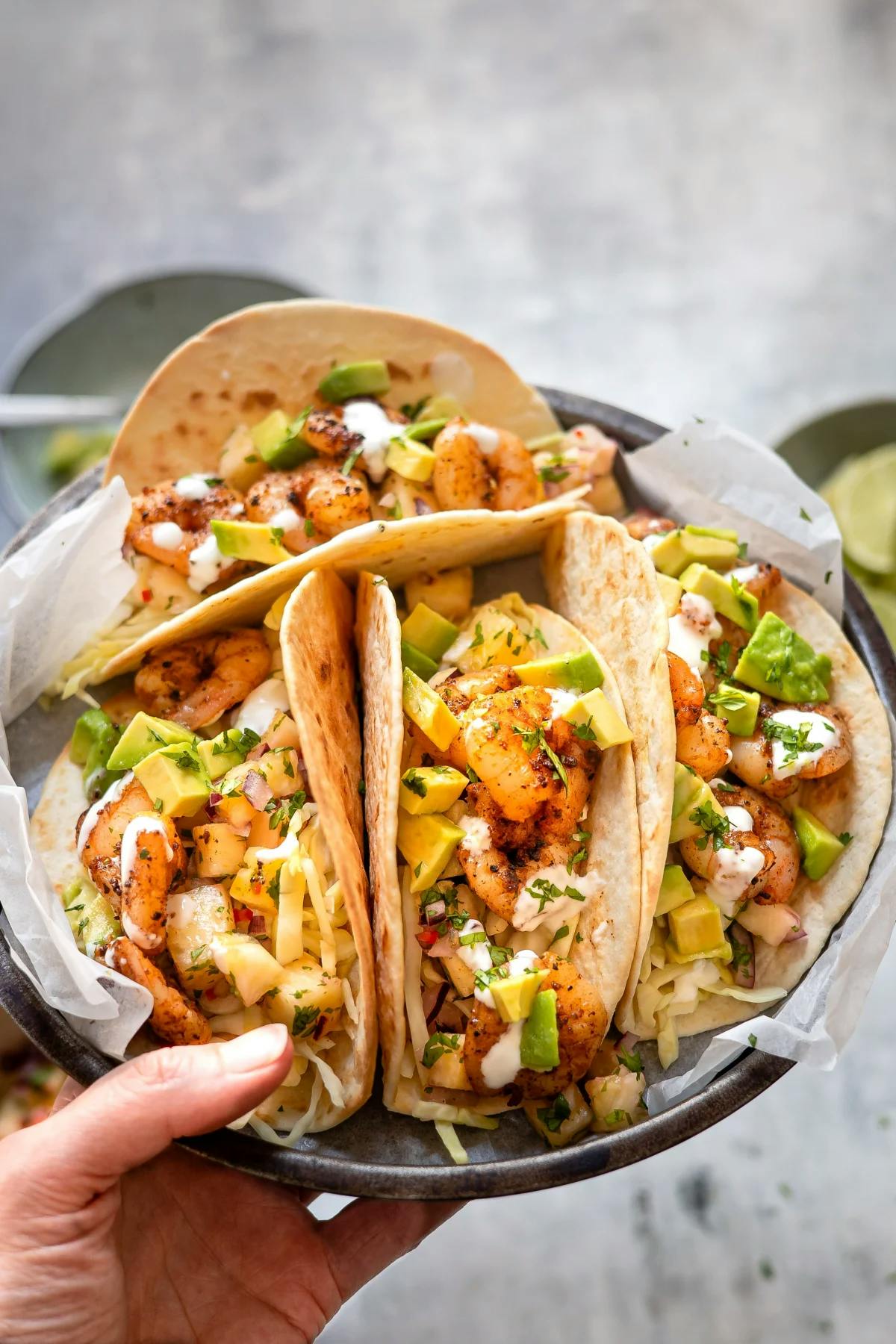 Person holds plate on tacos