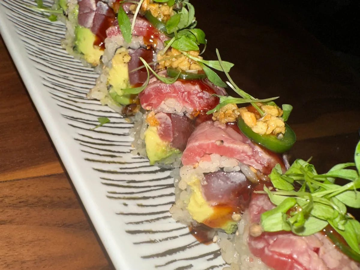 Sushi on a tray on a wooden table.