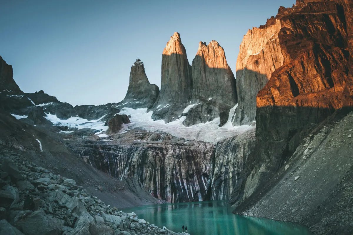 A mountain range with a lake in the foreground during the daytime