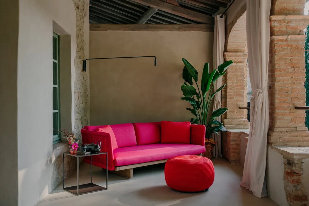 a bright-pink couch on an outdoor terrace