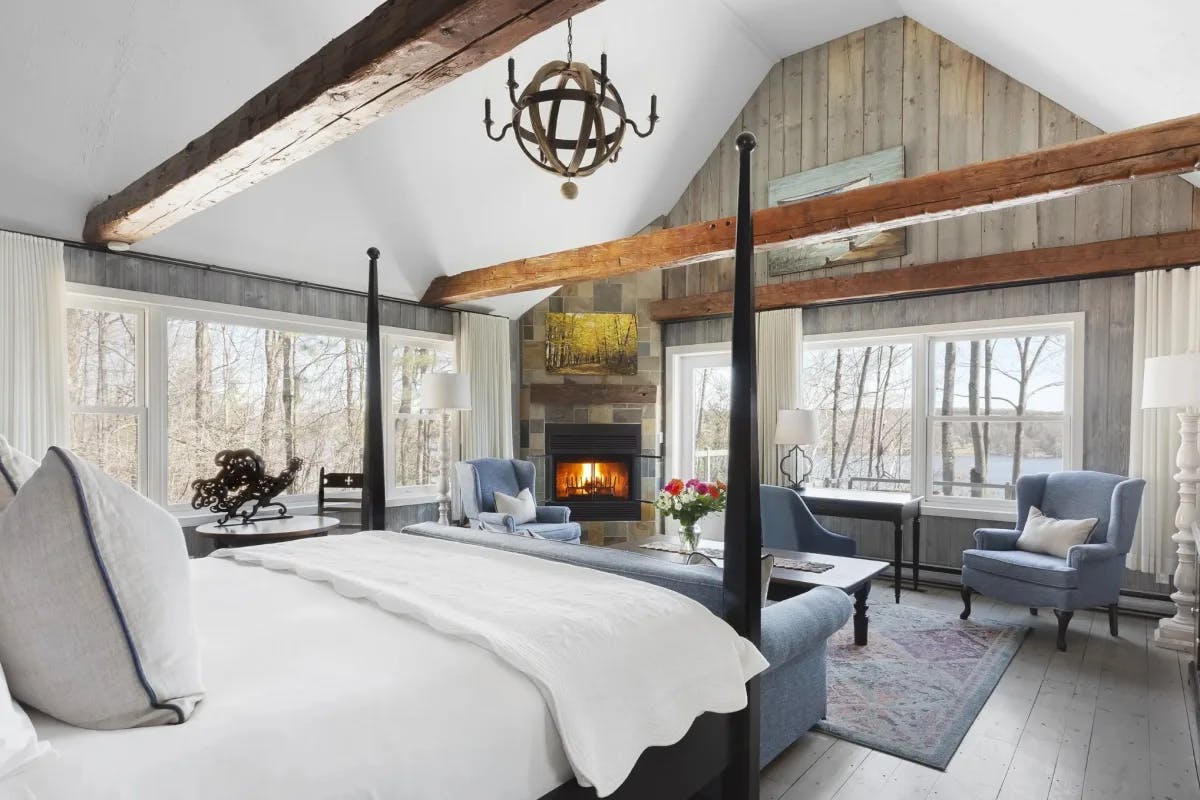 bedroom with vaulted ceilings, wood beams and a fireplace