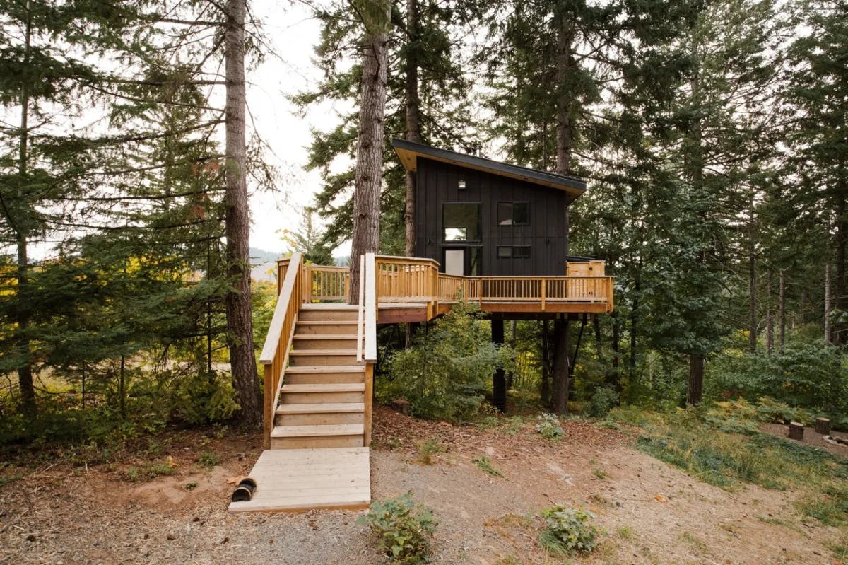 A charcoal grey treehouse on a deck.  