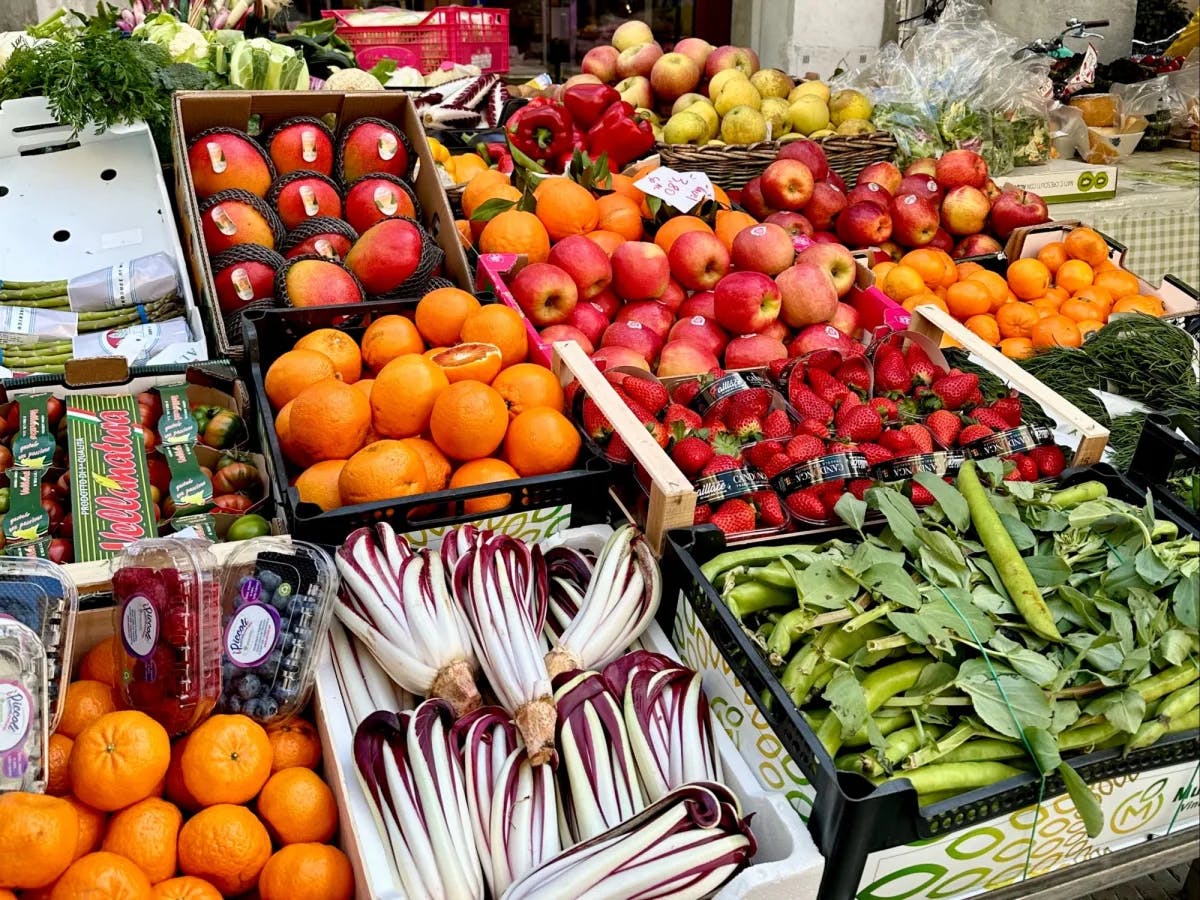A stall of fruits and vegetables outside in a market. 