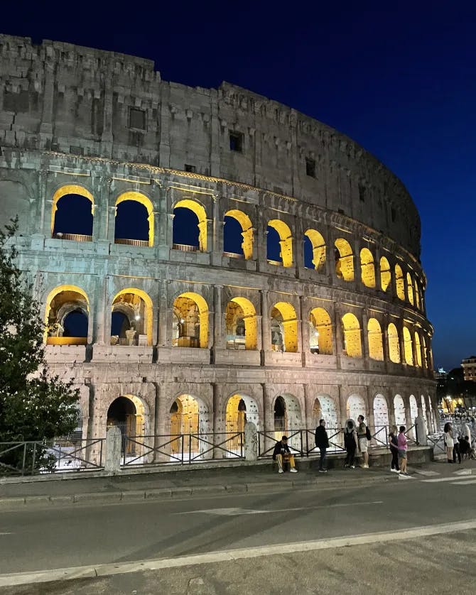 colosseum lit up at night time