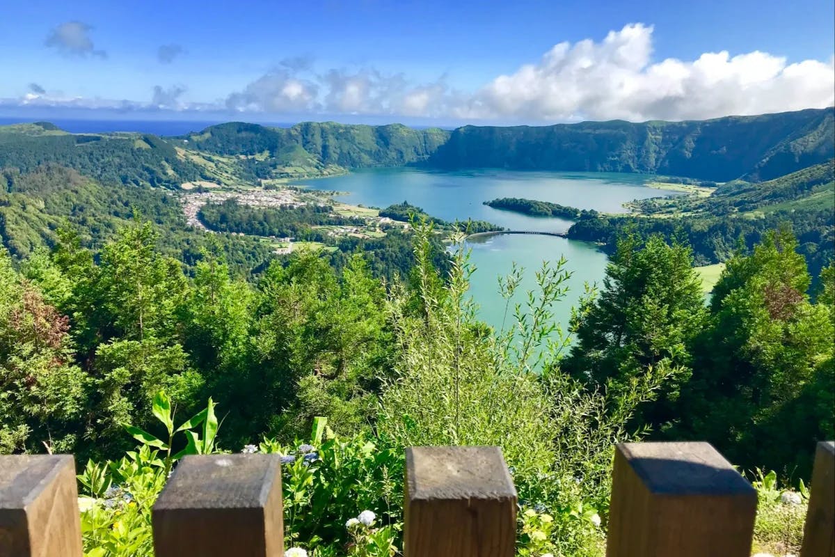 A photo of Lagoa do Fogo, a large blue crate lake in the middle of a mountain range, from an overlook.