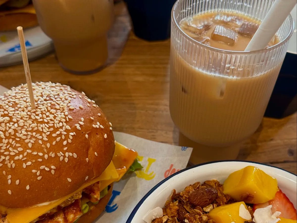 Burger and iced coffee on table.