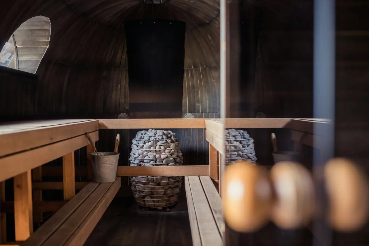 A view inside a steam room with wooden benches and hot stones at a spa.