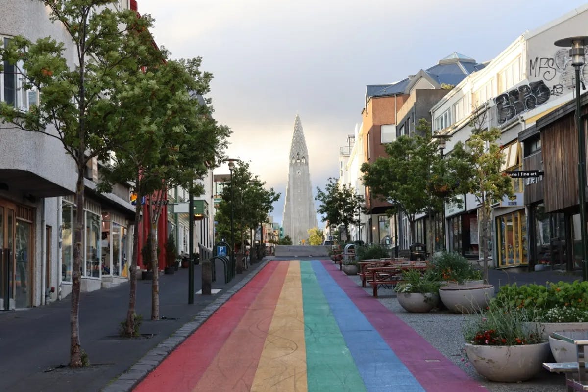 A road through city buildings painted in rainbow striped