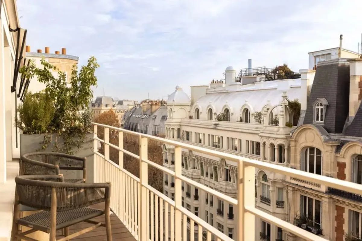 chairs on a balcony overlooking beautiful Paris skyline