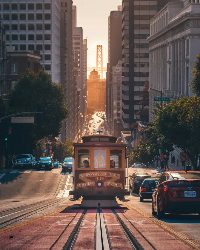 A trolly car going down a hill in San Francisco. 