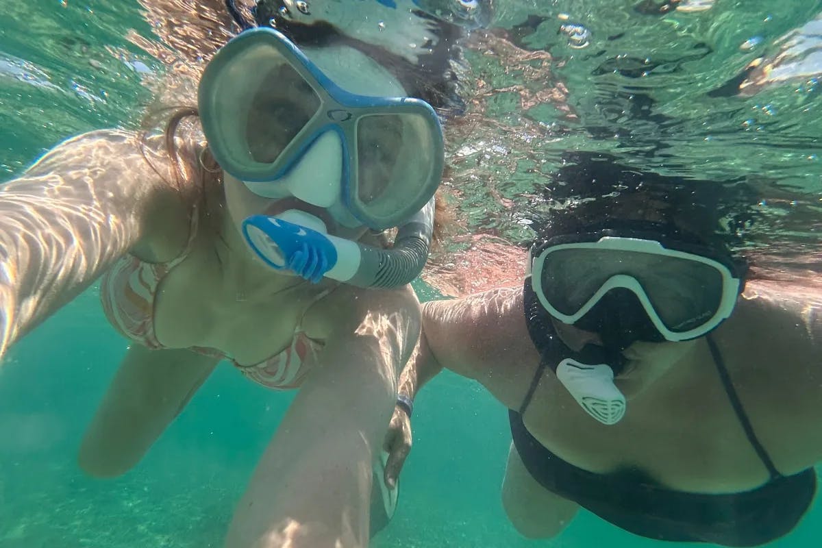 A selfie of two people underwater with snorkeling gear on. 