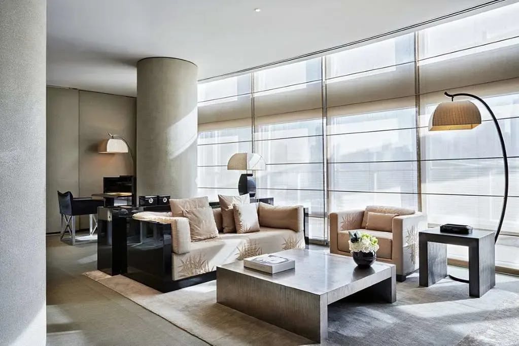 a luxe modern living room with a plush couch and armchair and a curved lamp