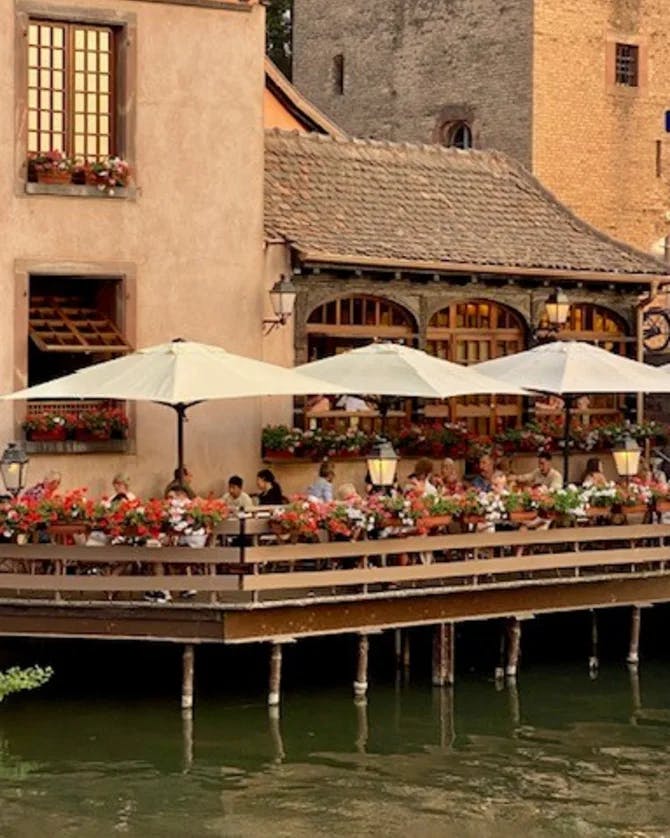 People dinning on an over water deck of a restaurant in France