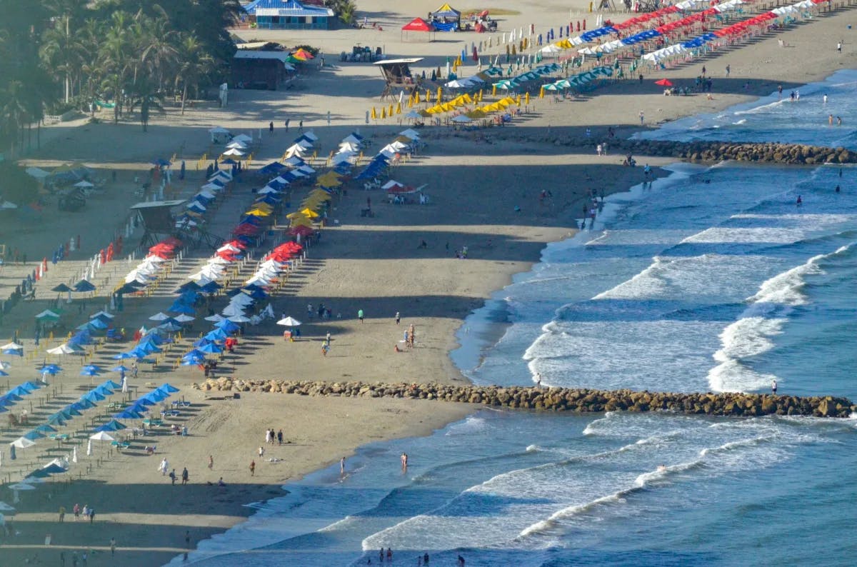Aerial view of beach with beach umbrellas and people.
