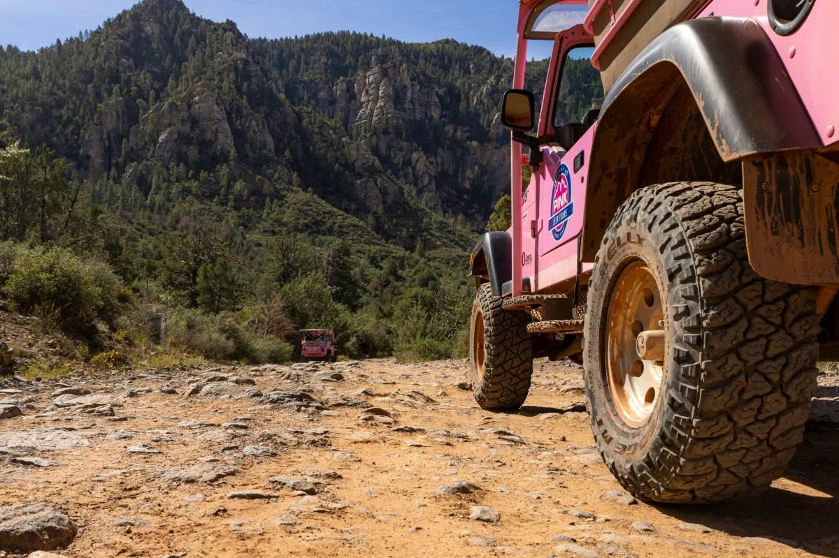 Pink jeep on a dirty road. 