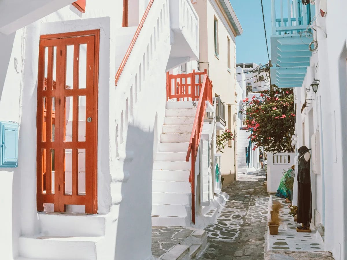 A quaint Mediterranean street with white buildings and colorful doors.