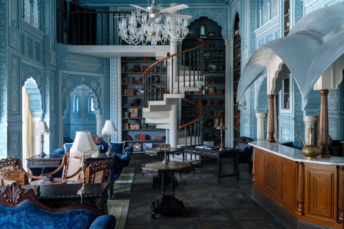 a blue library with a spiral staircase and a wall lined with books