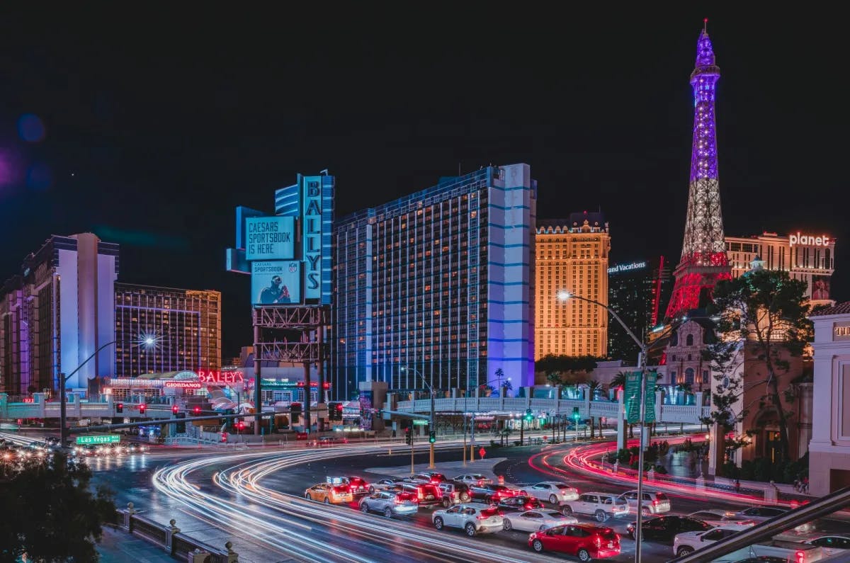 City of Las Vegas at night with traffic and neon lit buildings.