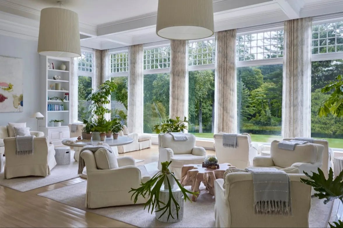 white room with huge windows and columns looking out to a green landscape