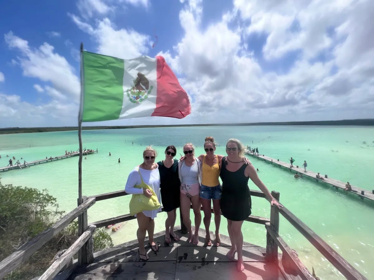 A picture of a group of girls posing in front of sea at Laguna Kaan Luum.