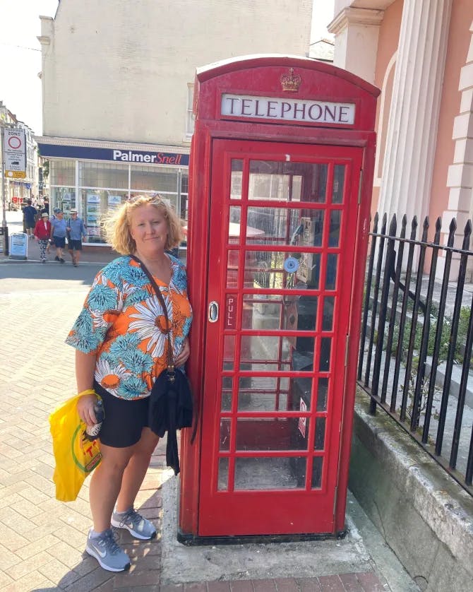 Travel advisor posing with a telephone booth