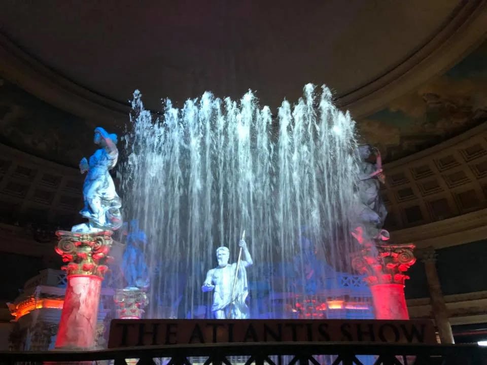 Fountain show inside a hall with statues around. 