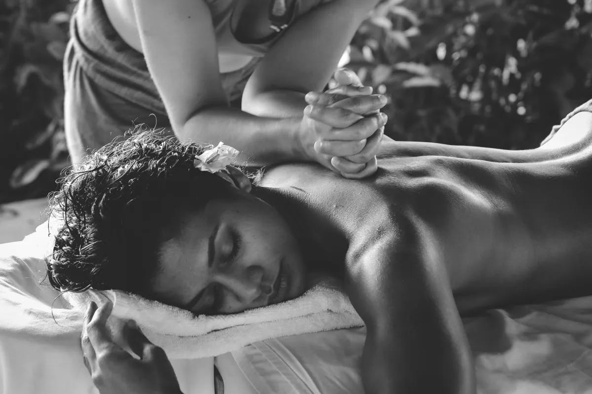 A grayscale picture of a woman getting a massage.