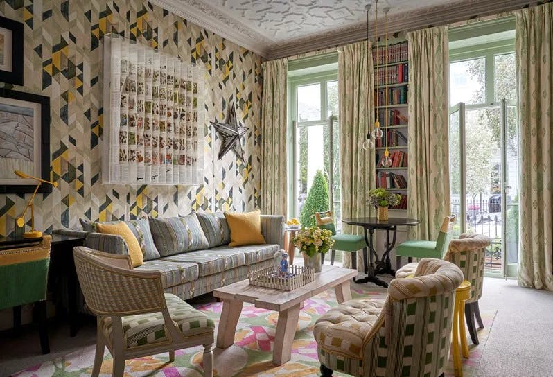 a sunlit living room with boldly patterned upholstered furniture