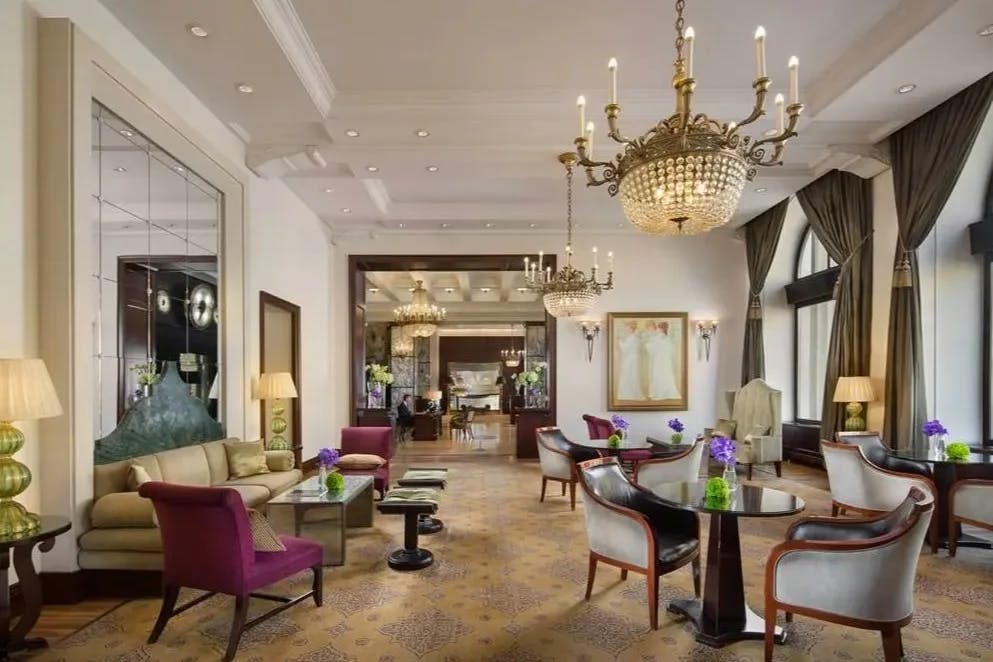 fancy hotel lobby with chandeliers and velvet seating