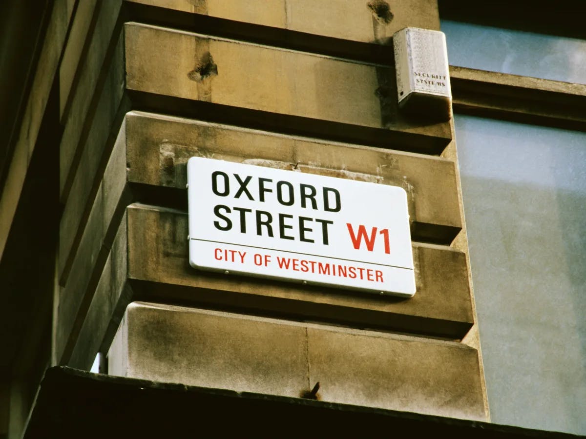 A street sign for “Oxford Street W1” is mounted on a building’s exterior wall in the City of Westminster.